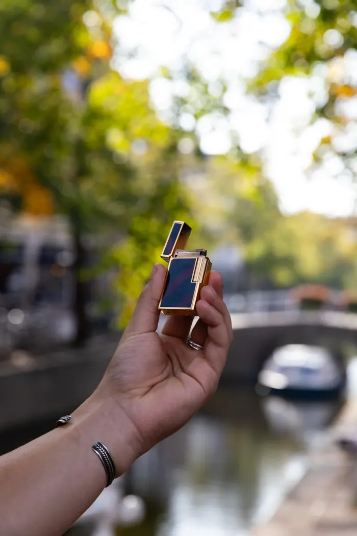 S.T. Dupont lighter held up over a canal in Delft