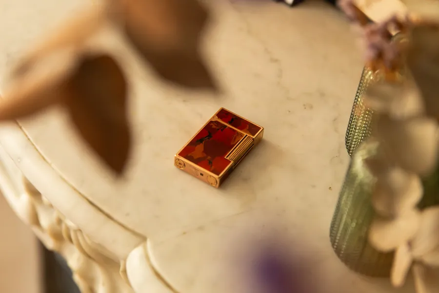 Red lacquered S.T. Dupont Ligne 2 lighter on a marble mantelpiece